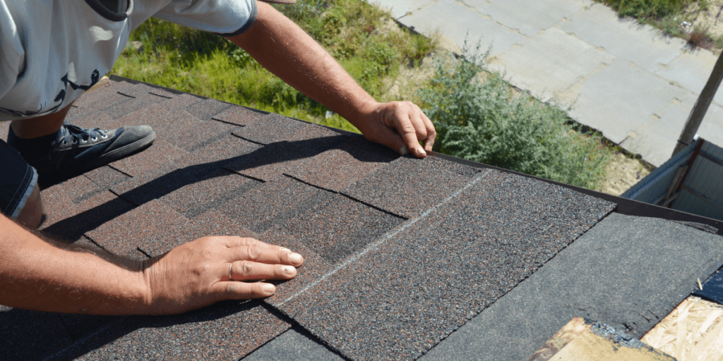 Roofing contractor installing asphalt shingles